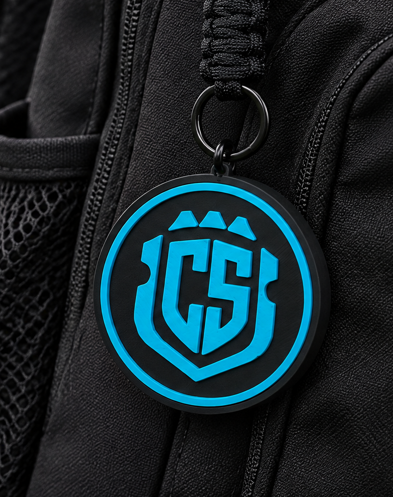 CS Futsal teal Tracker Tag attached to a black soccer backpack with black braided paracord and black carabiner