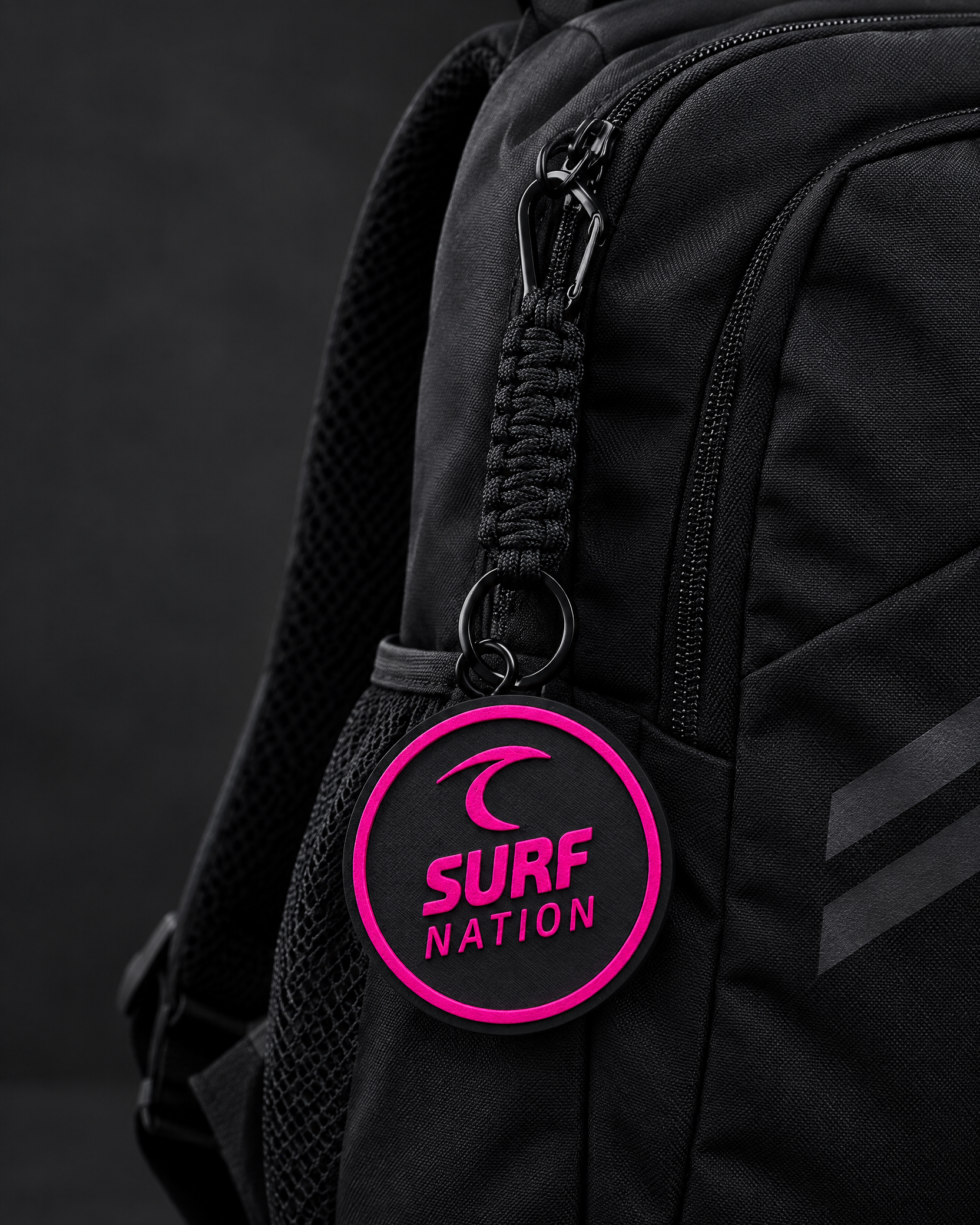 Black and hot-pink current Surf Nation Tracker Tag on a backpack