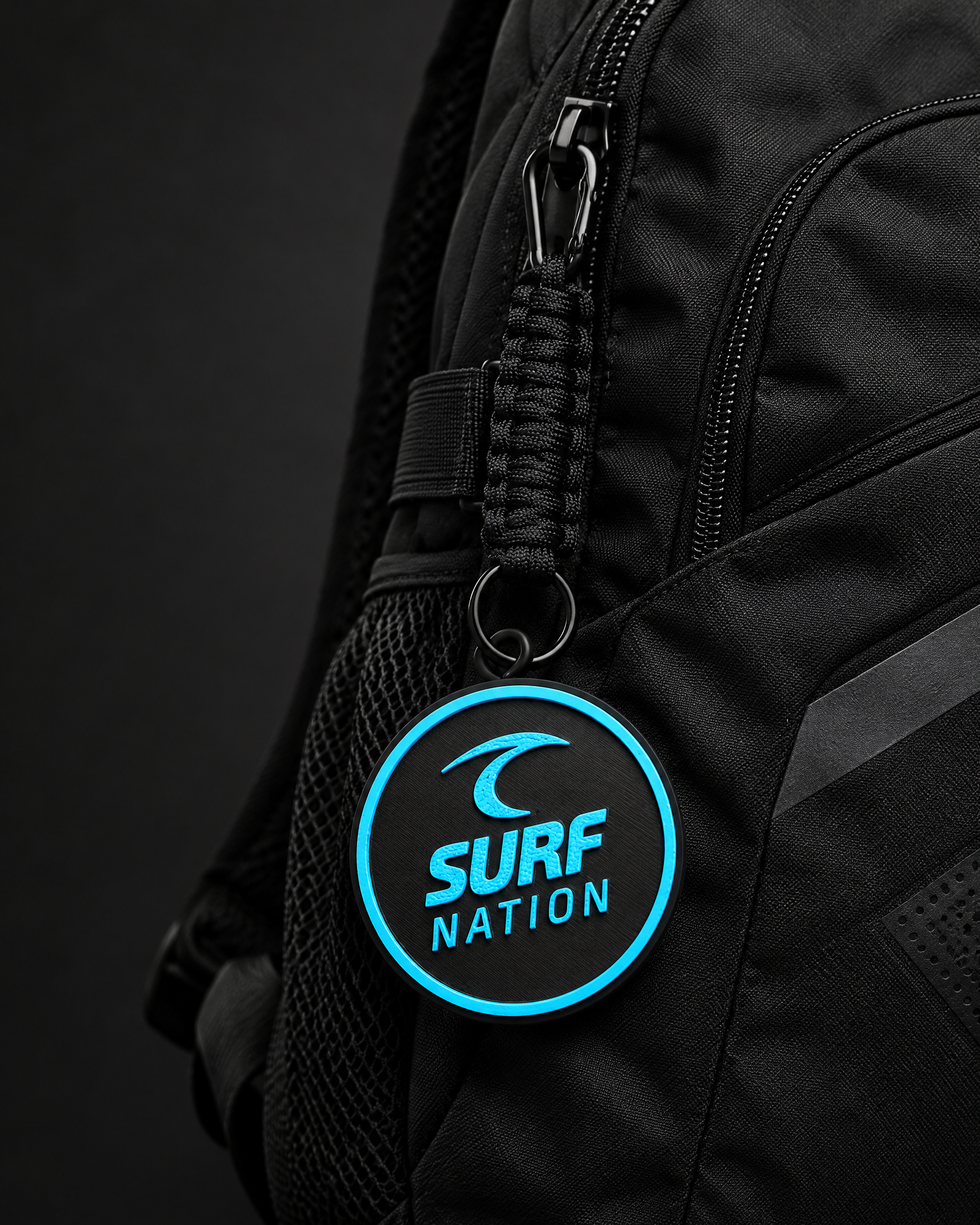 Black and Surf-blue current Surf Nation Tracker Tag on a backpack